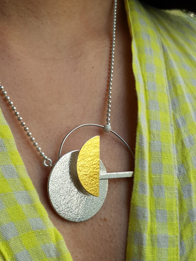 A geometric pendant made in silver, gold leaf and steel