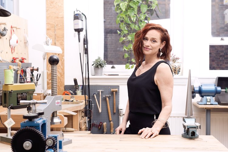 DeeLyn standing behind her jewellery work bench